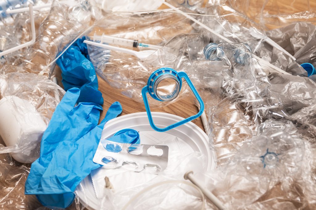 Pile of different plastic waste on wooden surface